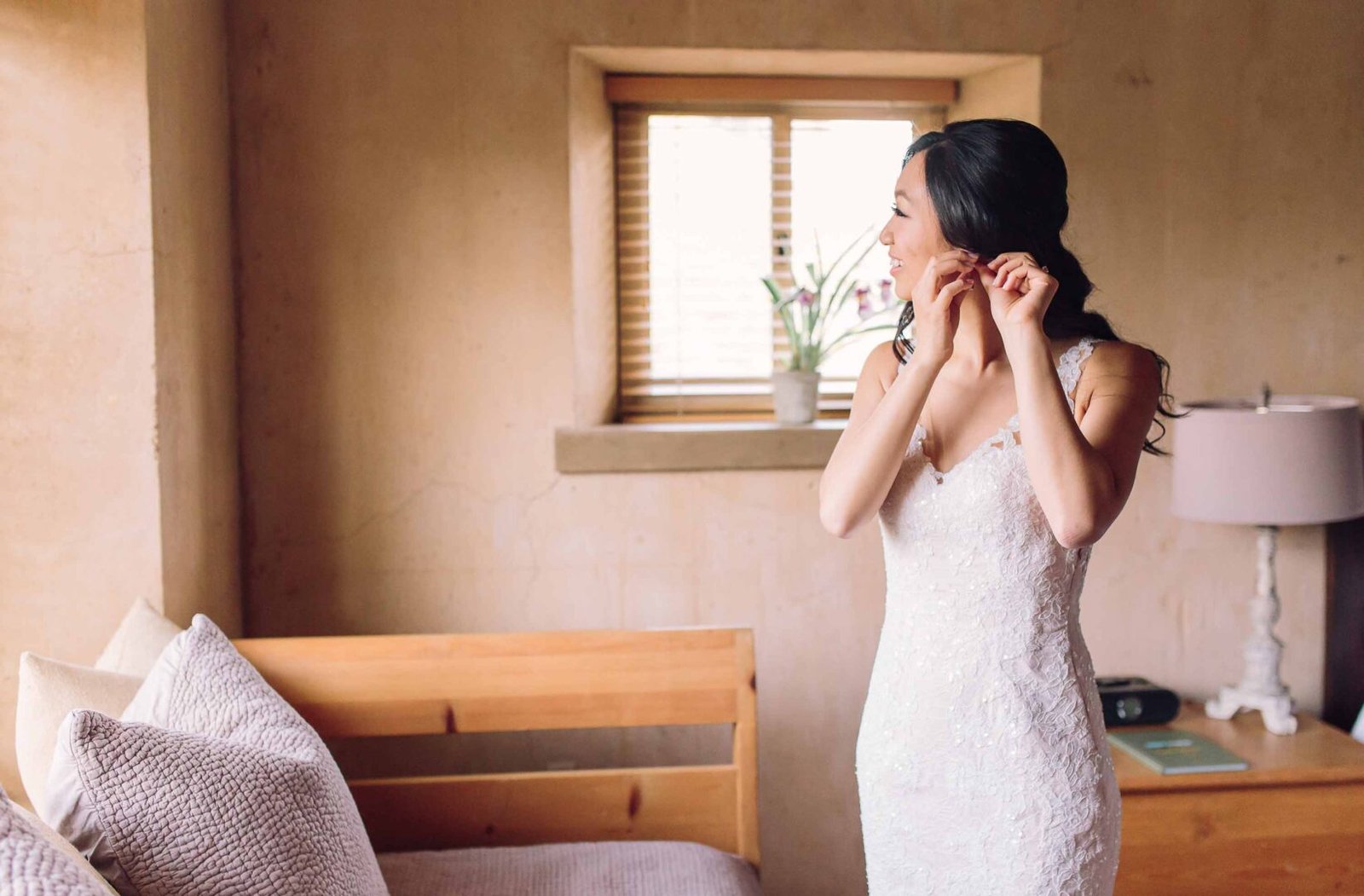 seven branches bride putting on some earrings