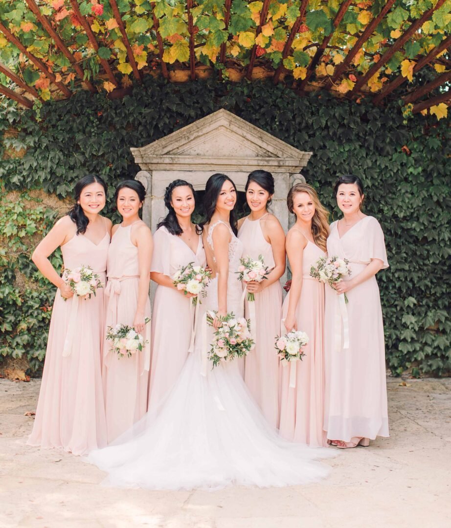 seven branches the courtyard ladies posing for a photo under an ark of leaves