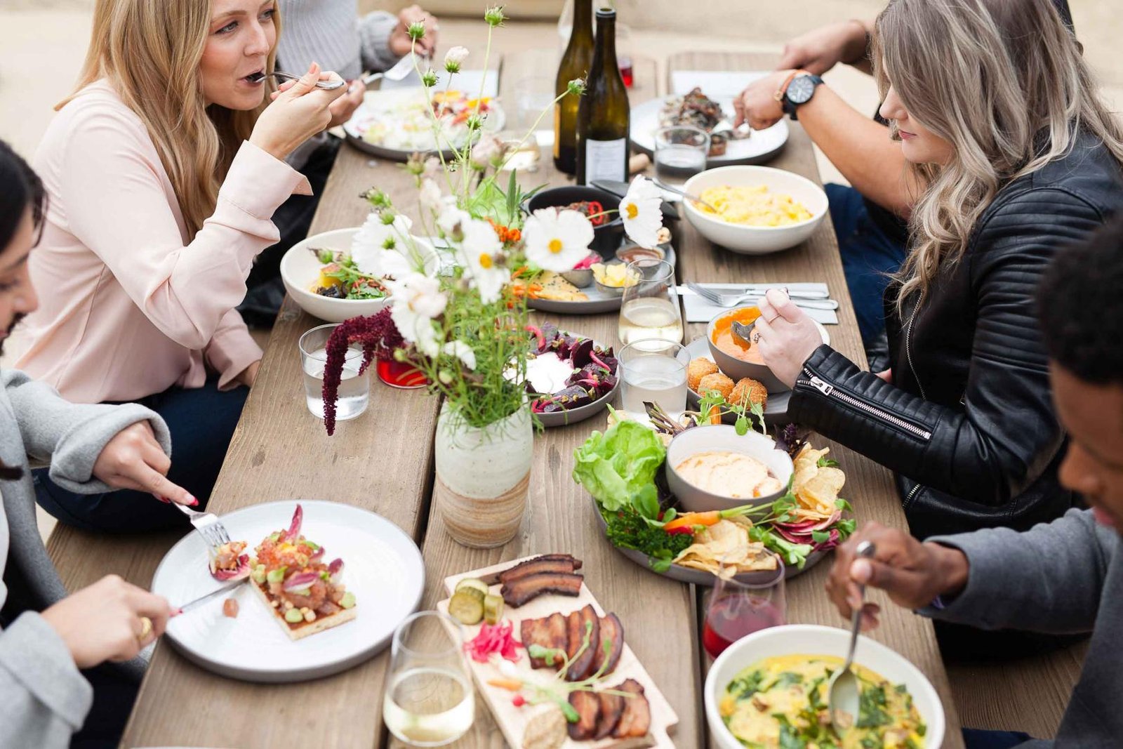people enjoying themselves over a really good meail full of different meal courses